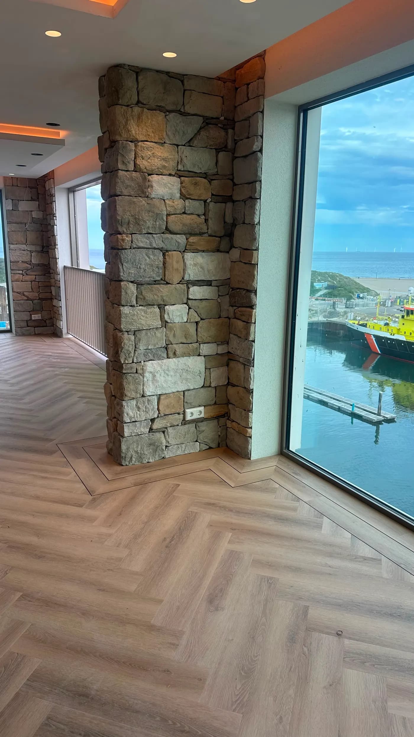 Visgraatvloer met natuursteen wand